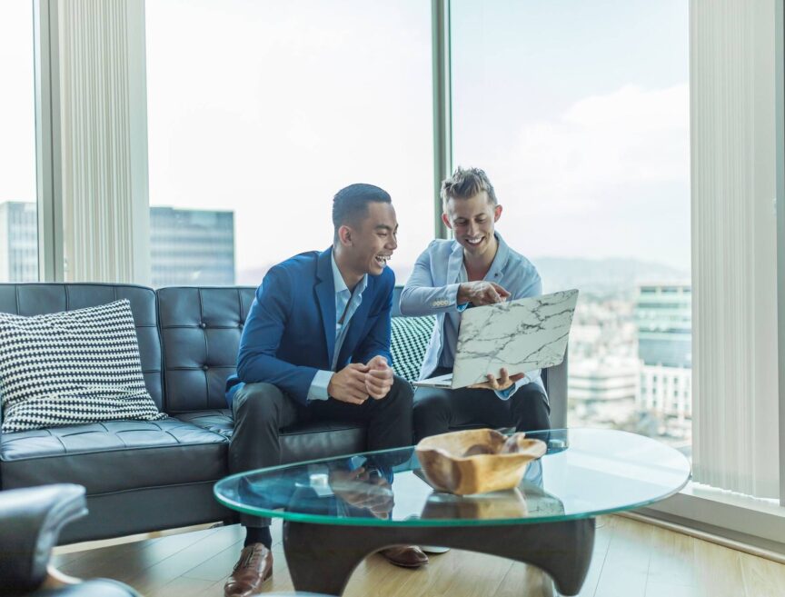 two men in suit sitting on sofa